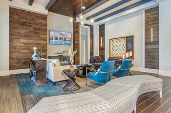 A living room with a white couch and blue chairs at Crabtree Lakeside Apartments, Raleigh, NC, 27612